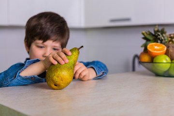 Fototapeta premium Little boy with a bowl of fresh fruits