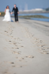 Unrecognizable newlywed couple walking on a beach