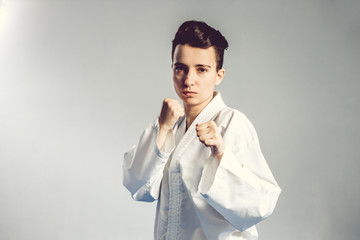 girl, Taekwondo is martial Stoke hands in fists, focused, serious look in the Studio on gray isolated background