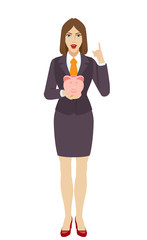 Businesswoman holding a piggy bank and pointing up