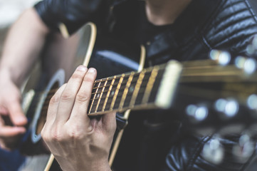 Young aspiring guitar musician posing with his guitar and enjoying while playing it