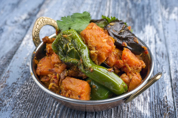 Indian Vegetable Curry Fry with Sweet Potatos and Eggplant as close-up in a Kadai
