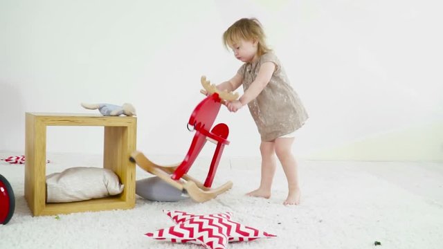 Small baby girl playing with the toy horse slow motion