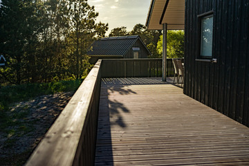 Fototapeta premium Holzterrasse im Ferienhaus beim Sonnenuntergang
