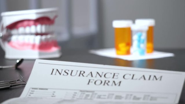 Insurance claim form on dentist's desk focus pull.