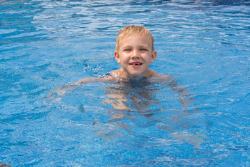 Fototapeta na wymiar Boy swimming and playing in a pool