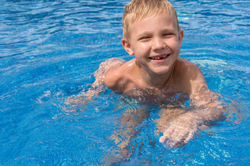 Fototapeta na wymiar Boy swimming and playing in a pool