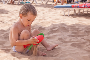 Little boy playing in the waves at sea on a sunny day