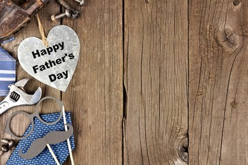 Happy Fathers Day metallic heart with side border of tools and ties on a wooden background