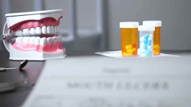 Focus pull on a mouth ulceres diagnostic sitting on dentist's desk.