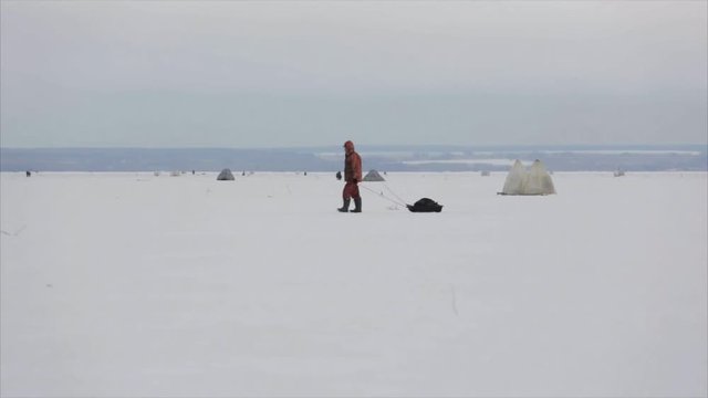 Man fishing at winter time on the lake cover with ice - 6