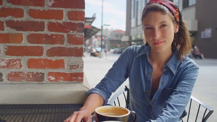 Hipster young woman sitting outside a coffee shop, portrait