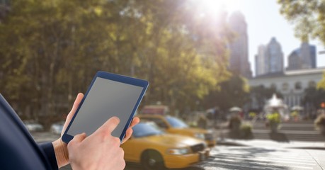 Hands with tablet in front of taxis in the city