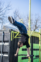 Young Athlete doing a Hand Stand On Parallel Bars In An Outdoor Gym - Street Workout Exercises. Man's flexibility.