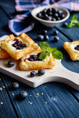 Baked square cakes topped with ricotta and blueberry