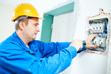 Fototapeta premium electrician installing switching electric actuator in fuse box