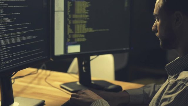 Serious professional hacker being involved in coding