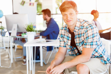 Young man sitting and looking at camera in office