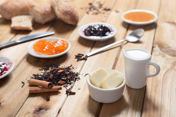 Crispy rolls with butter, apple and berry jam for breakfast