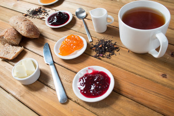 Crispy rolls with butter, apple jam and hot tea for breakfast