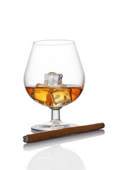 Glass of strong alcoholic drink scotch whiskey with ice cube and cigar