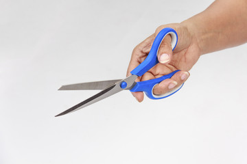   woman's hand holding  scissors on white background.