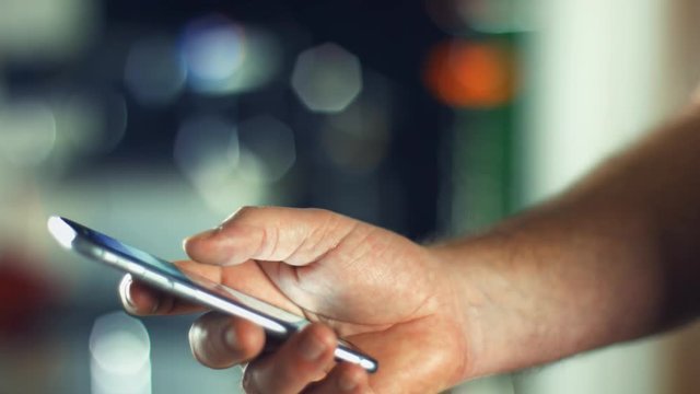 Using a Smartphone, sliding the screen and taping, close up shot with soft bokeh