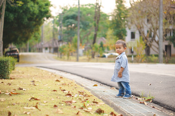 Obraz premium Asian boy learning to walk across the street