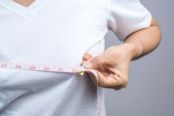 Woman measuring her small breast size