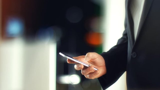 Using a Smartphone, sliding the screen and taping, close up shot with soft bokeh