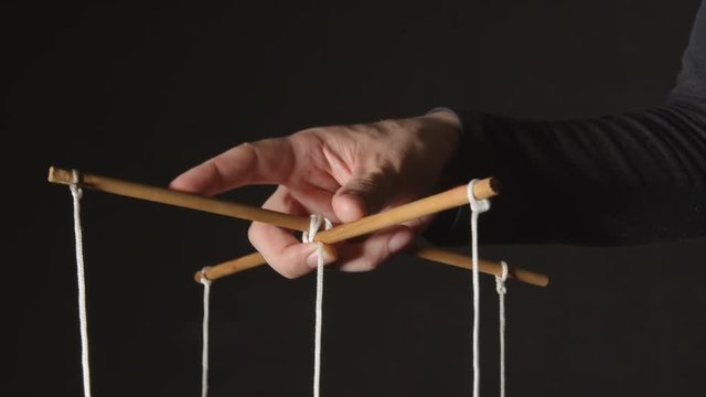 MANIPULATION: Hand of a puppeteer - Close up