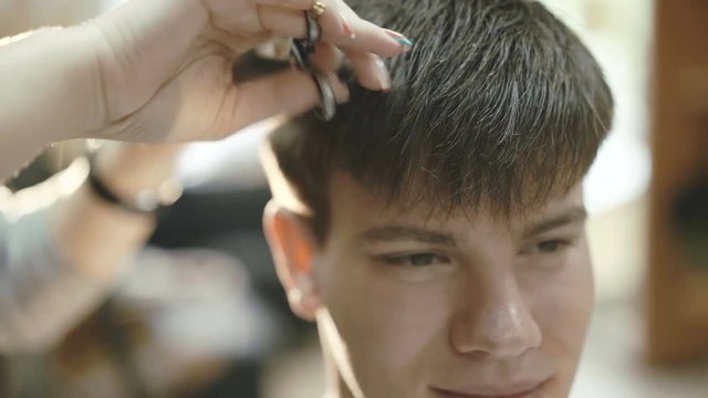 Close up of the handsome man with smile gets a haircut in the salon 4K