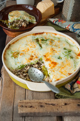 Young cabbage lasagna stuffed with vegetables and rice with bechamel  sauce in ceramic dish on a wooden background. Rustic style.