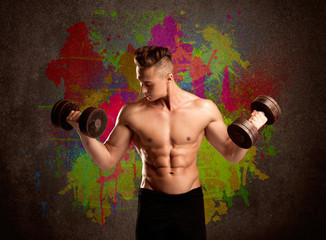 Strong guy with colorful paint wall and weight