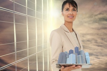 Composite image of woman holding buildings in 3d