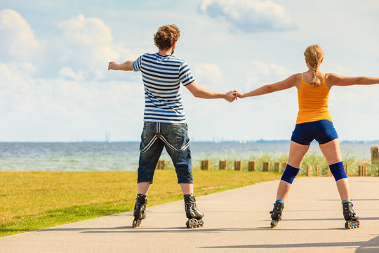 Young couple on roller skates riding outdoors