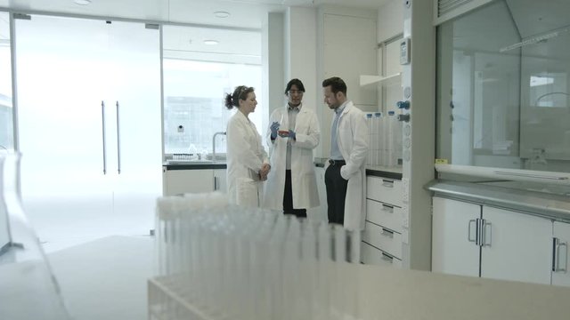 Team of scientists discussing liquid experiment