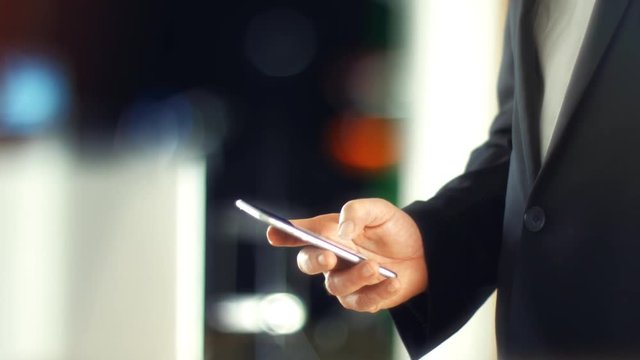Using a Smartphone, sliding the screen and taping, close up shot with soft bokeh
