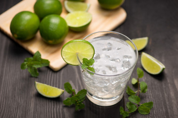 Fresh cocktail with lime, ice and mint on a rustic background. Copy space, top view