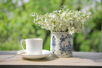 Still life with a white porcelain cup and vase from Delft porcelain with white flowers in the morning light