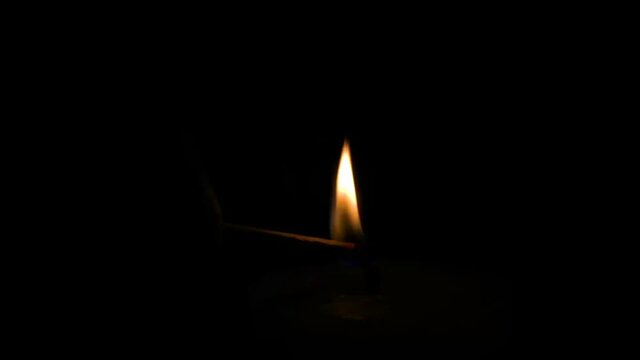 lighting a candle with a match in a dark space