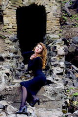 A young woman with blond hair and skin in a black elegant dress and high heeled shoes near the abandoned tunnel unravels her own secrets of her soul, the emphasis on psychology