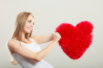 woman holding heart shaped pillow love symbol