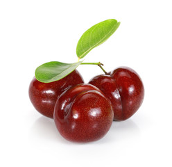 Whole and half ripe purple cherry plums