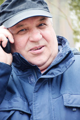 Senior caucasian man speaking by mobile phone in the forest 