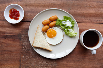 Quick and easy breakfast, fried eggs with sausages, toast and salad.