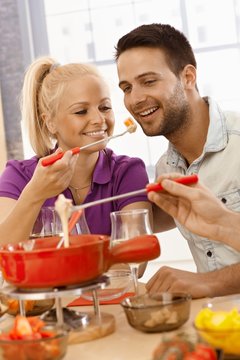 Loving couple having cheese fondue