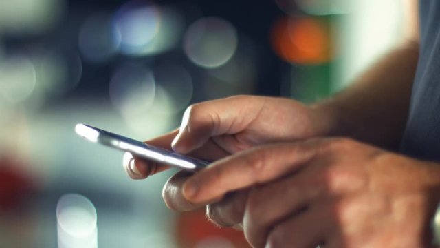 Using a Smartphone, sliding the screen and taping, close up shot with soft bokeh