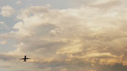Passenger airplane taking off at sunset against the background of a very beautiful clouds.