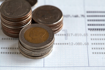 Coins stack on passbook, saving or investment concept.
